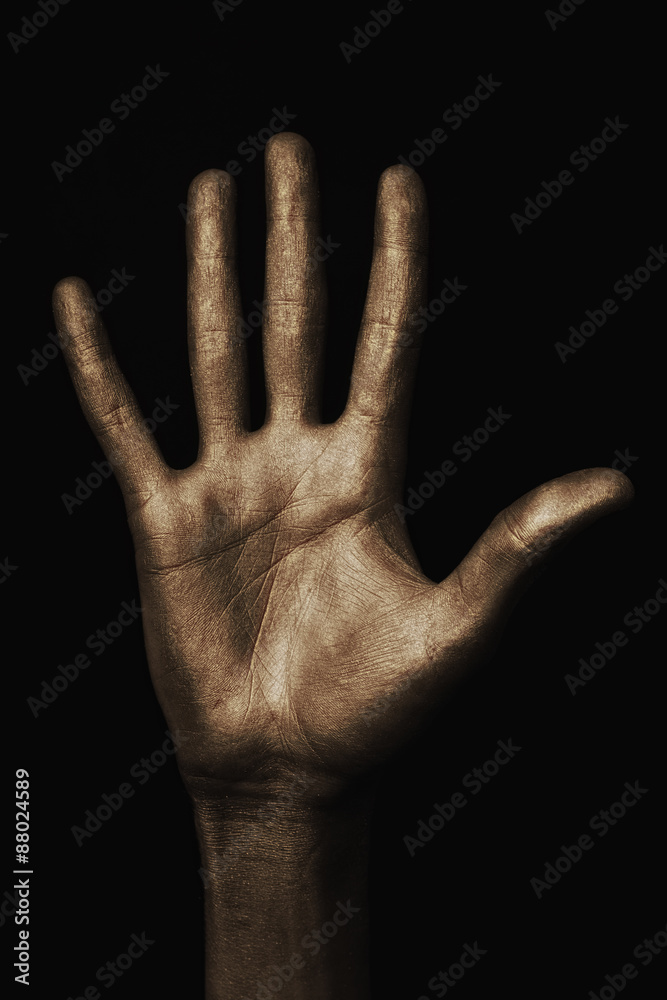 Fototapeta premium beautiful man's hand in golden paint on black background