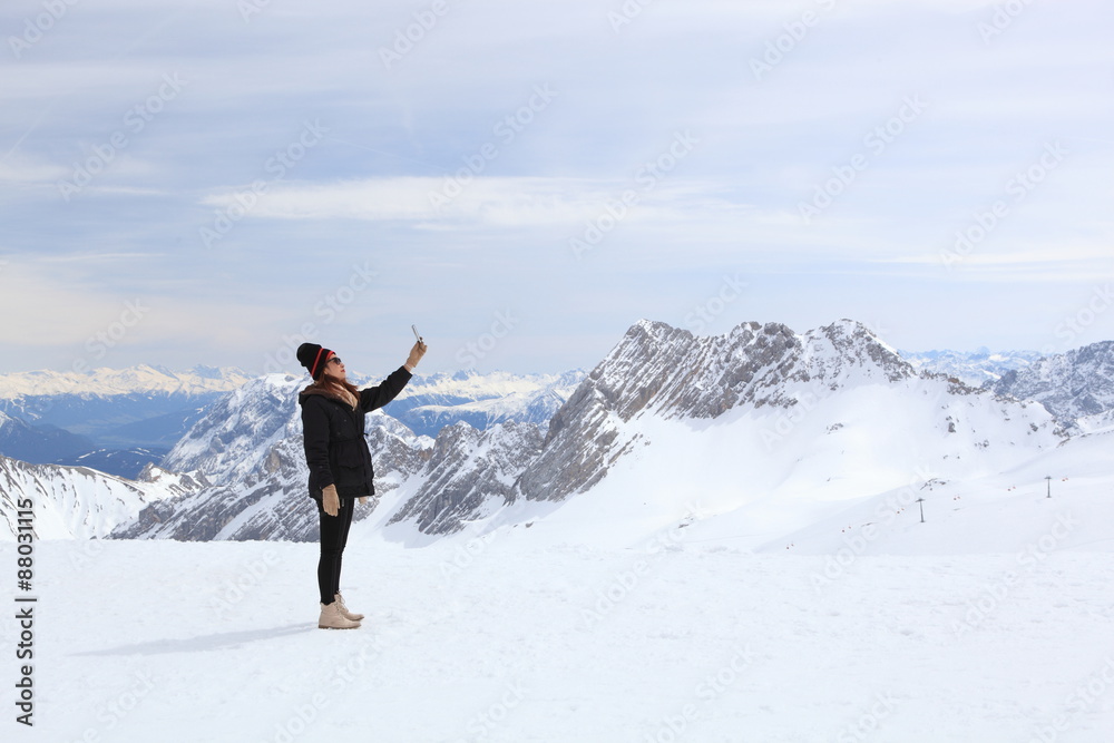 Winter snow covered mountain Zugspitze in Germany Europe. women take photo by herself at moment time