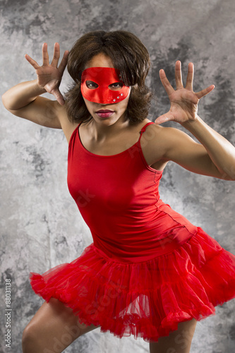 Female dancer in red camisole dress and red mask.