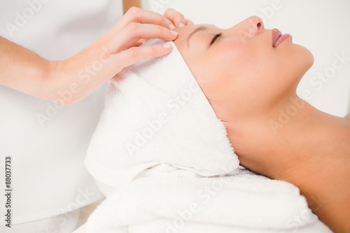 Attractive young woman receiving forehead massage 
