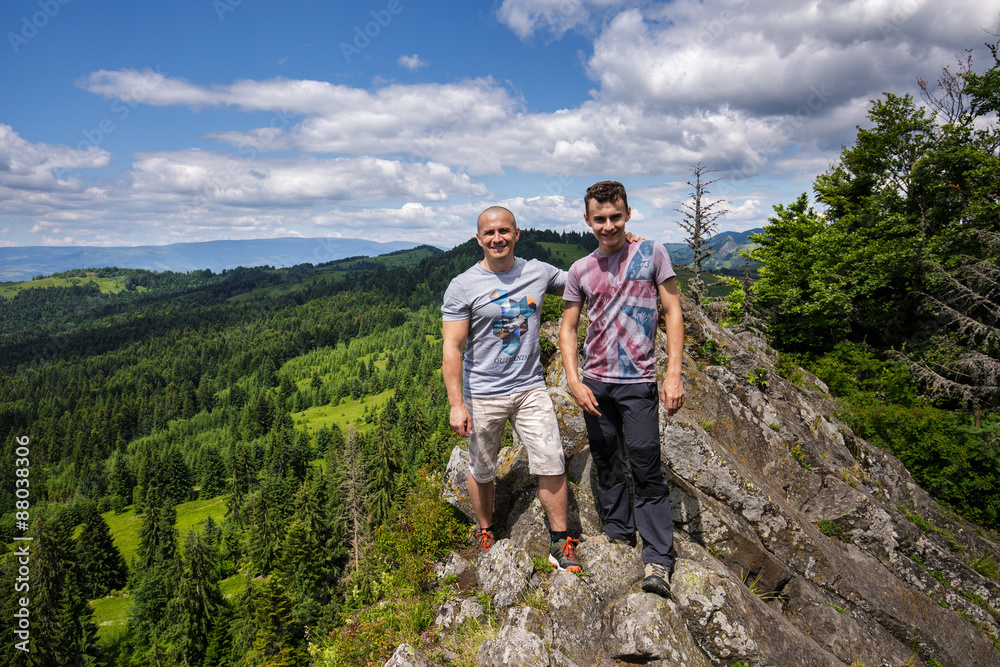 Father and son standing on a mountain top Father and son standing on a mountain top