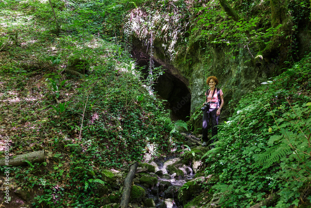 Woman standing near a cave