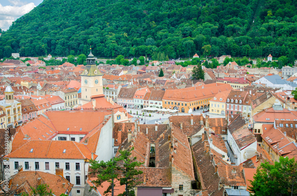 Brasov, Romania - 29.06.2015: Brasov old historic medieval city center in a view from above with the town hall and Sfatului Square showing the cultural and historic heritage in the Romanian city