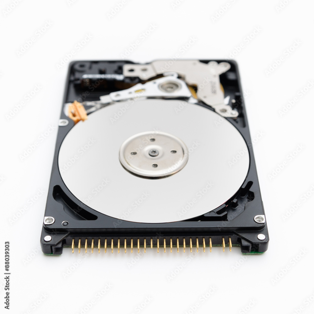 Open hard disk drive on a white siolated background in a close look in an imposing serious perspective showing the disks and the blurred writing head Open hard disk drive on a white siolated background in a close look in an imposing serious perspective showing the disks and the blurred writing head