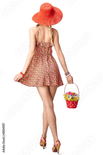 Joyful boho woman in sundress with basket of wildflowers 