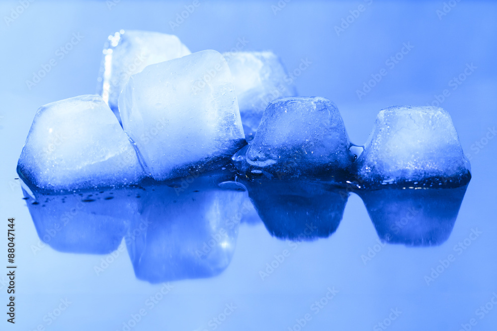Ice cubes on blue reflective surface Ice cubes on blue reflective surface