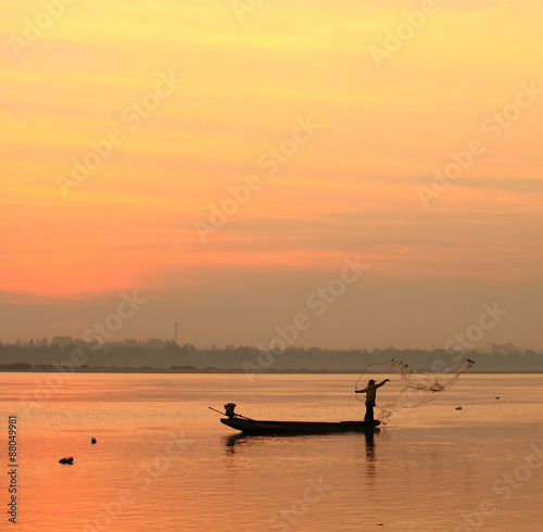 fishmonger in his traditional boat at sunrise