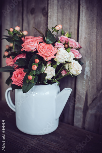 Fototapeta Naklejka Na Ścianę i Meble -  Bouquet of roses in vintage coffee pot
