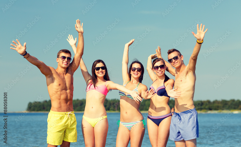 smiling friends in sunglasses on summer beach smiling friends in sunglasses on summer beach