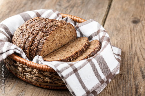 Rye bread with seeds in the basket on a wooden table