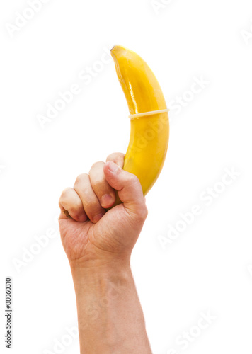 Condom on banana in hand isolated on white background 