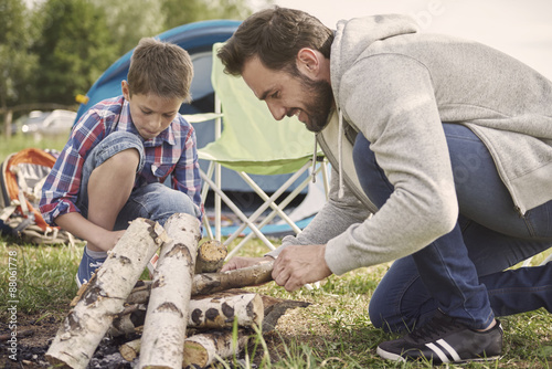 Pensive boy helping his father on camping photo