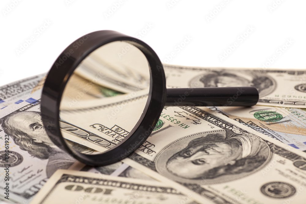 Fototapeta premium Hundred dollar banknote under magnifying glass