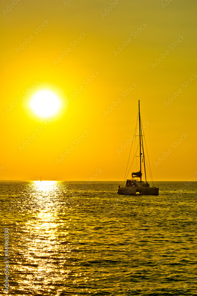 Catamaran sailboat at golden sunset