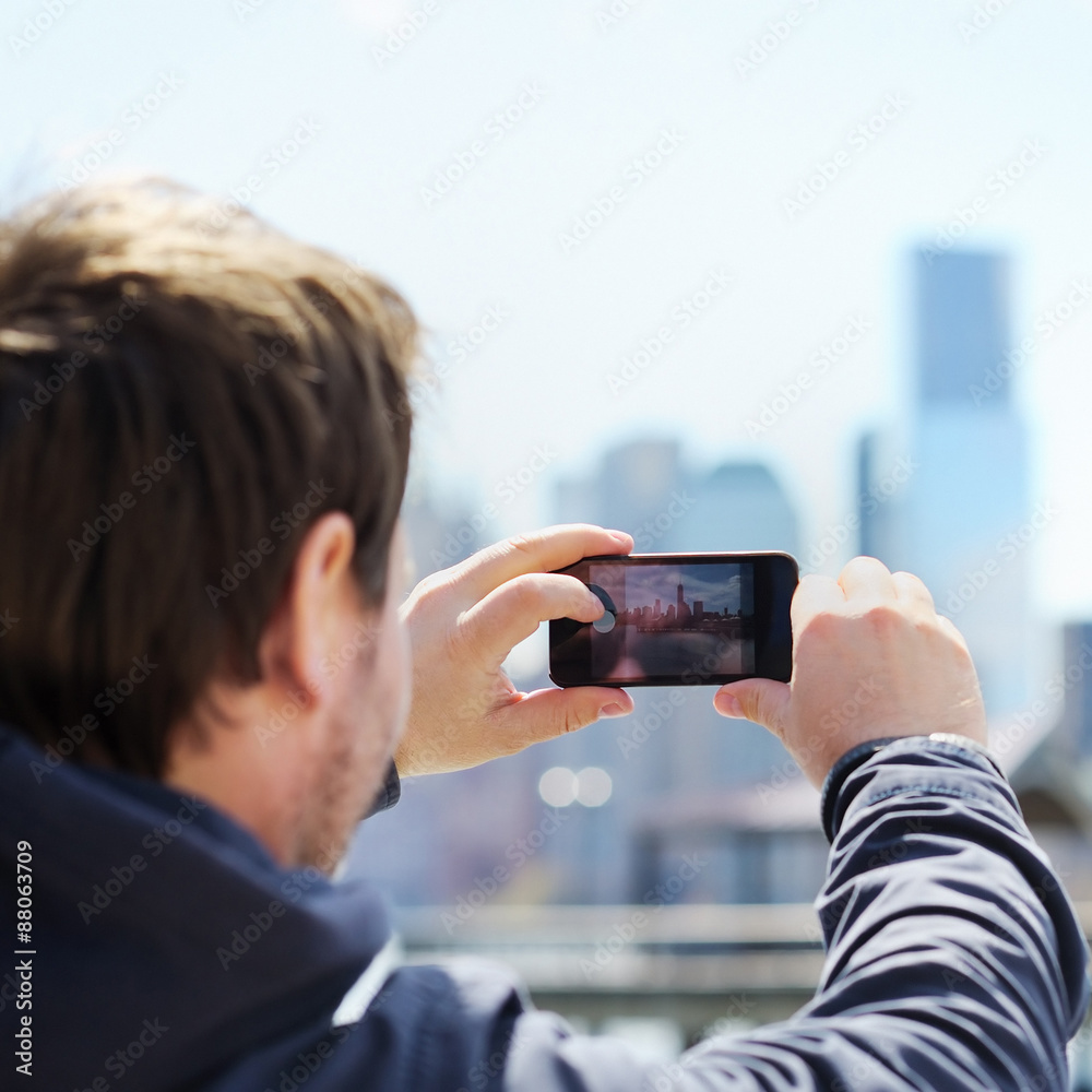 Fototapeta premium Tourist taking mobile photo of skyscrapers