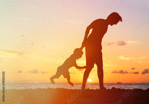 silhouettes of father and son having fun at sunset