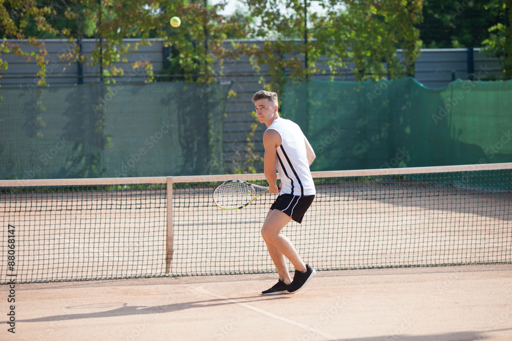 young man play tennis outdoor on orange court young man play tennis outdoor on orange court