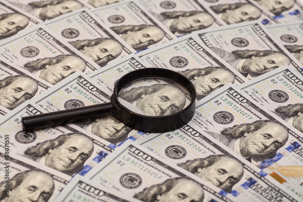 Hundred dollar banknote under magnifying glass Hundred dollar banknote under magnifying glass