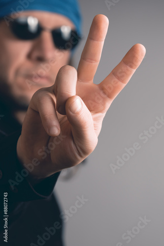 Long Haired Man with sunglasses showing the peace sign