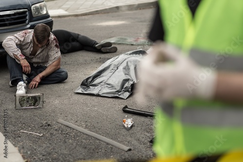 Injured man sitting on the street