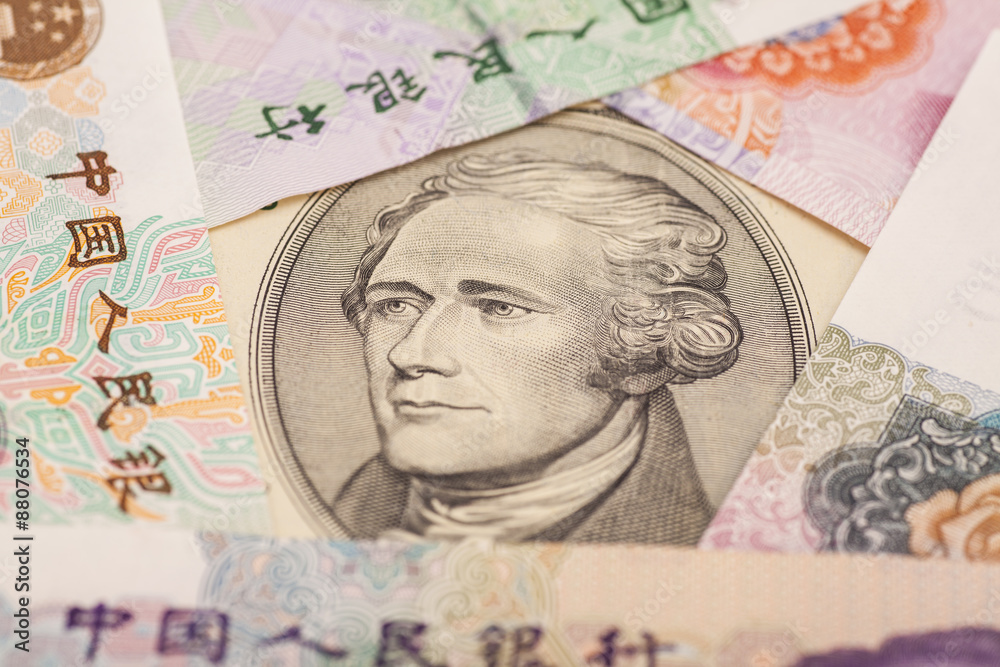Ten dollar bill surrounded by Chinese Yuan