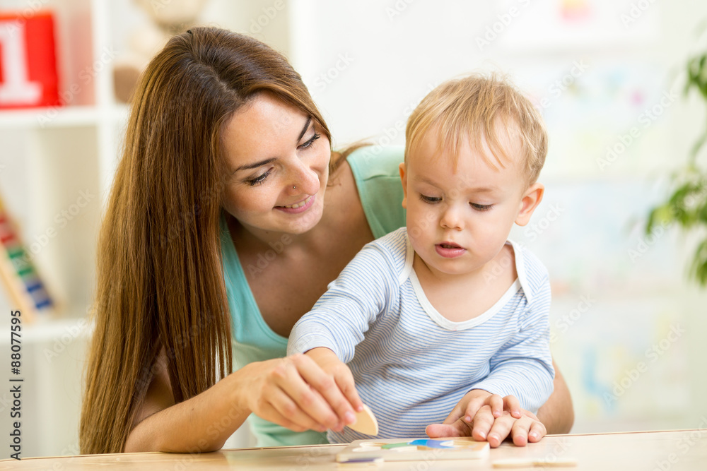 mother and her child play with colorful puzzle toy mother and her child play with colorful puzzle toy