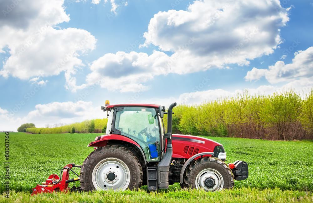 Red tractor mows the grass. Red tractor mows the grass.