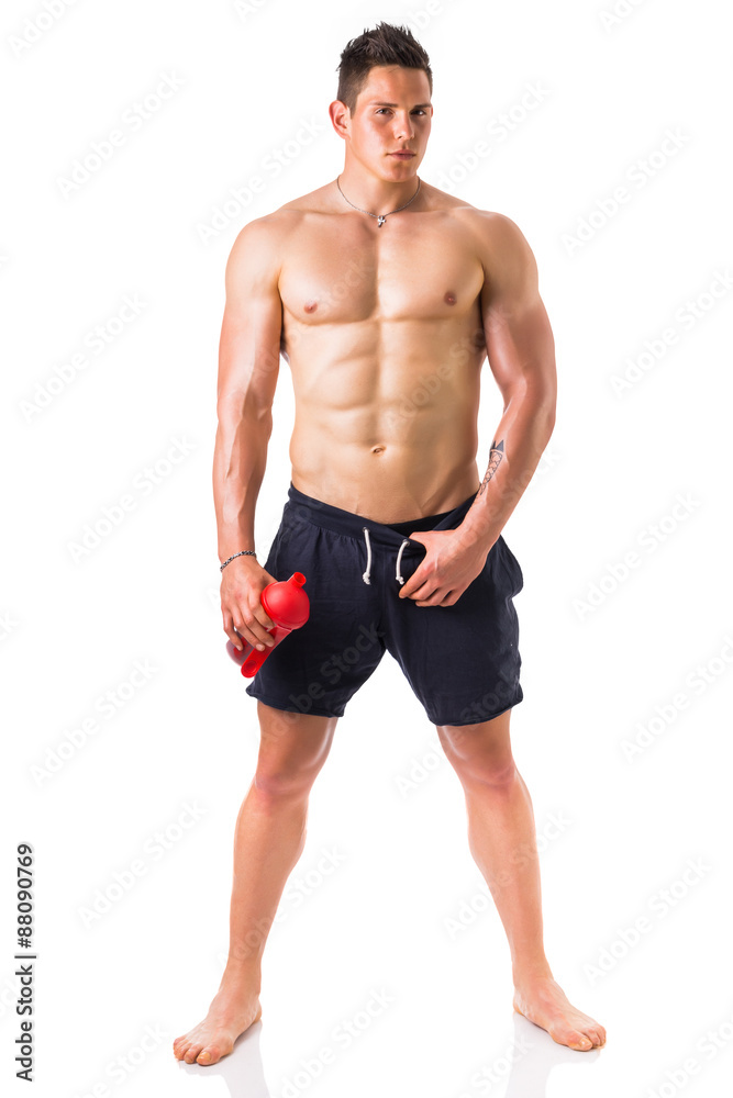 Muscular young man holding protein shake bottle