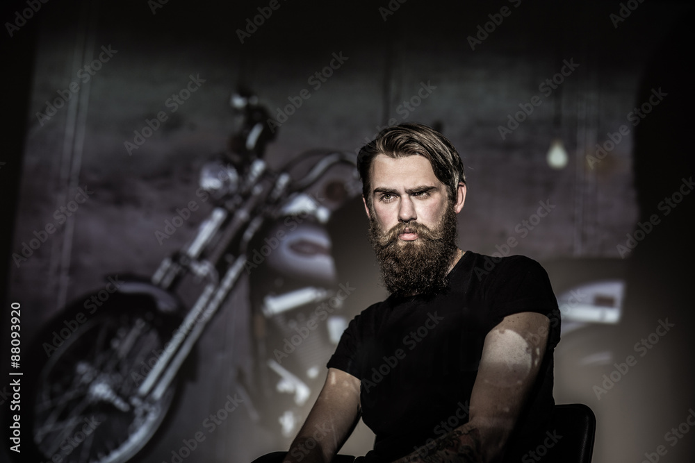 Naklejka premium Brutal angry biker on a dark background.