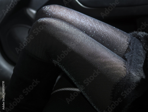 Slender sexy legs in shiny pantyhose in car