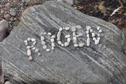 Rügen geschrieben mit Kiesel auf Granitfels photo