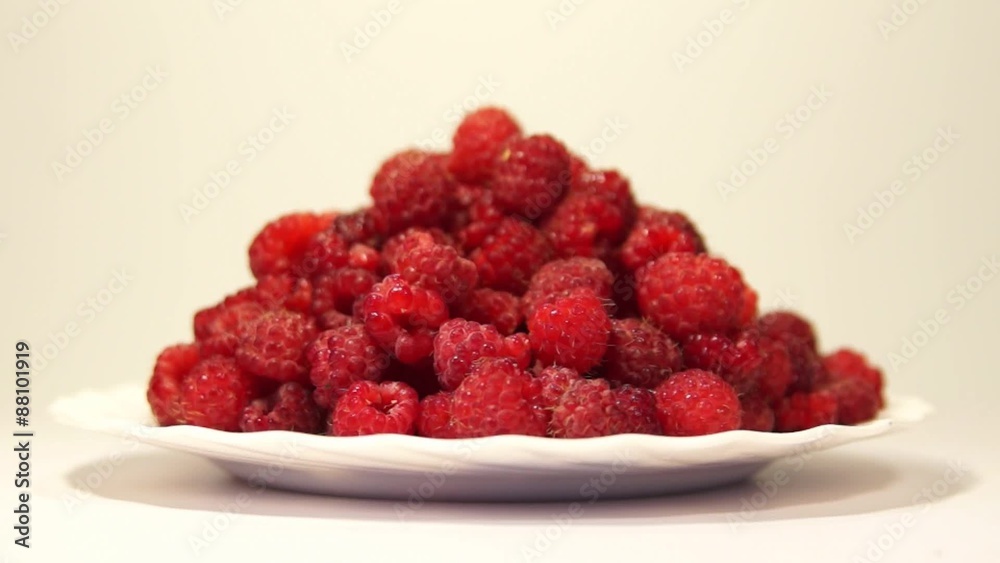 White plate with fresh red raspberries rotating White plate with fresh red raspberries rotating