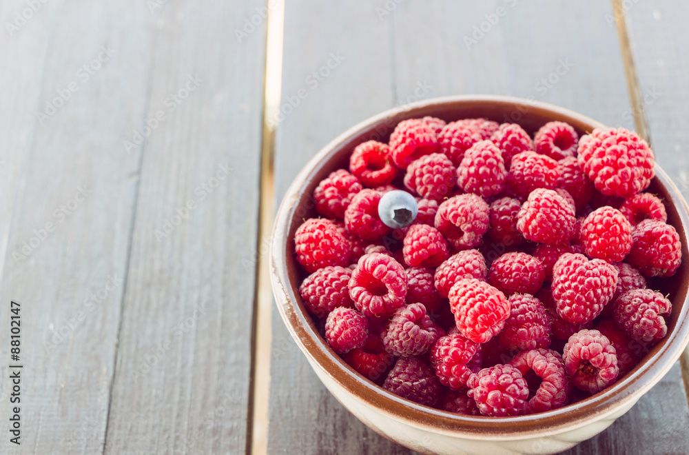 Fresh raspberries in plate on a wooden table Fresh raspberries in plate on a wooden table