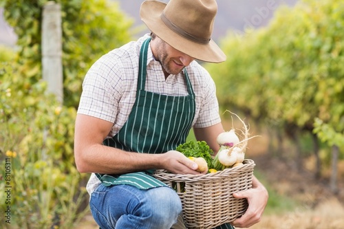 Young happy farmer holding a basket of vegetables © WavebreakmediaMicro