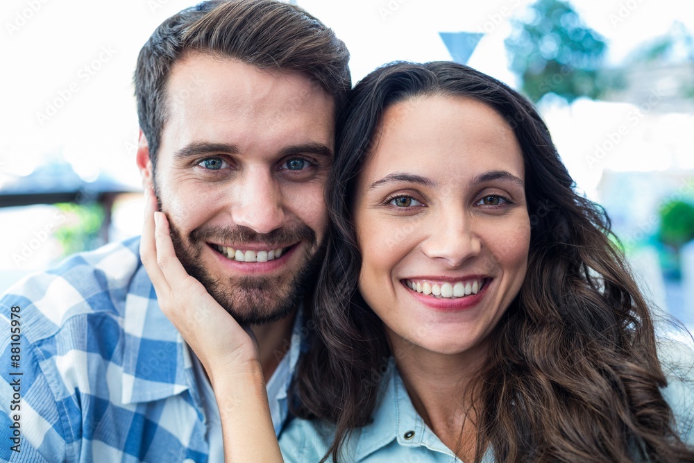 © WavebreakmediaMicro - Cute couple sitting outside a cafe smiling at camera © WavebreakmediaMicro - Cute couple sitting outside a cafe smiling at camera