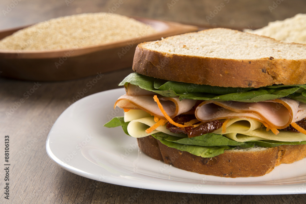Sandwich on a white plate with turkey breast, tomato and lettuce Sandwich on a white plate with turkey breast, tomato and lettuce