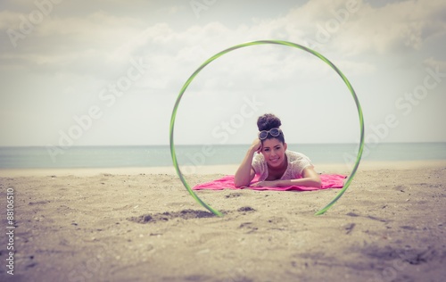 Smiling woman looking at camera through hula hoop