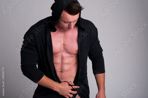 Young muscular man wearing an open hoodie