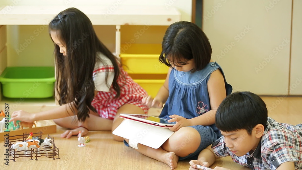 Group of Little Asian child playing together with a computer tablet . Group of Little Asian child playing together with a computer tablet .