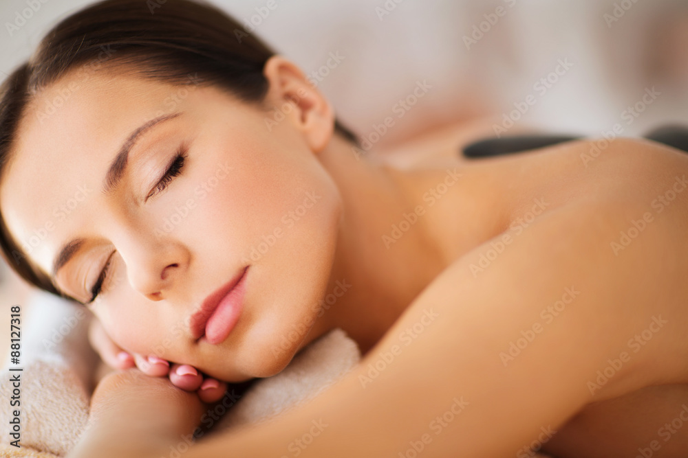 Obraz premium beautiful woman in spa salon with hot stones