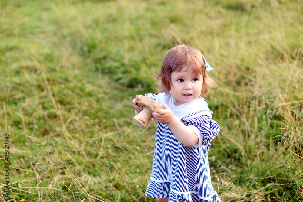 Cute little girl 'taking pictures' with her wooden camera on the pasture Cute little girl 'taking pictures' with her wooden camera on the pasture