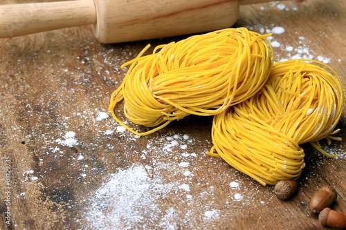 yellow noodles drying on wood background