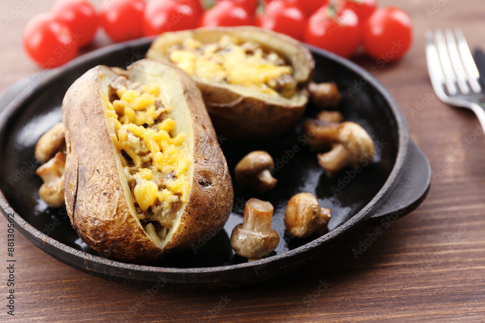 Baked potatoes with cheese and mushrooms on table close up Baked potatoes with cheese and mushrooms on table close up
