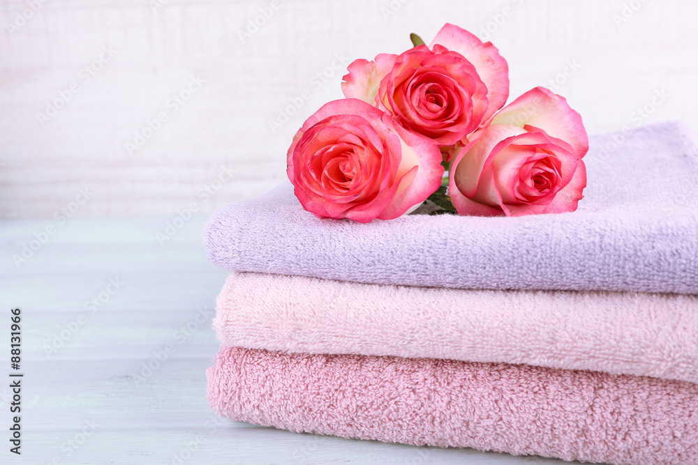 Stack of colorful towels on light wooden background Stack of colorful towels on light wooden background