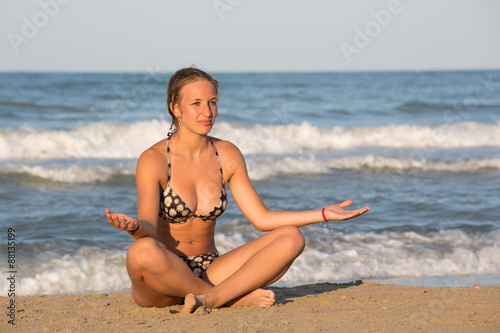 Girl practicing yoga at sea