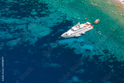 Luxury white pleasure yacht near rocky coast © evannovostro
