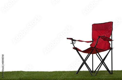 Folding camp chair on grass with white background