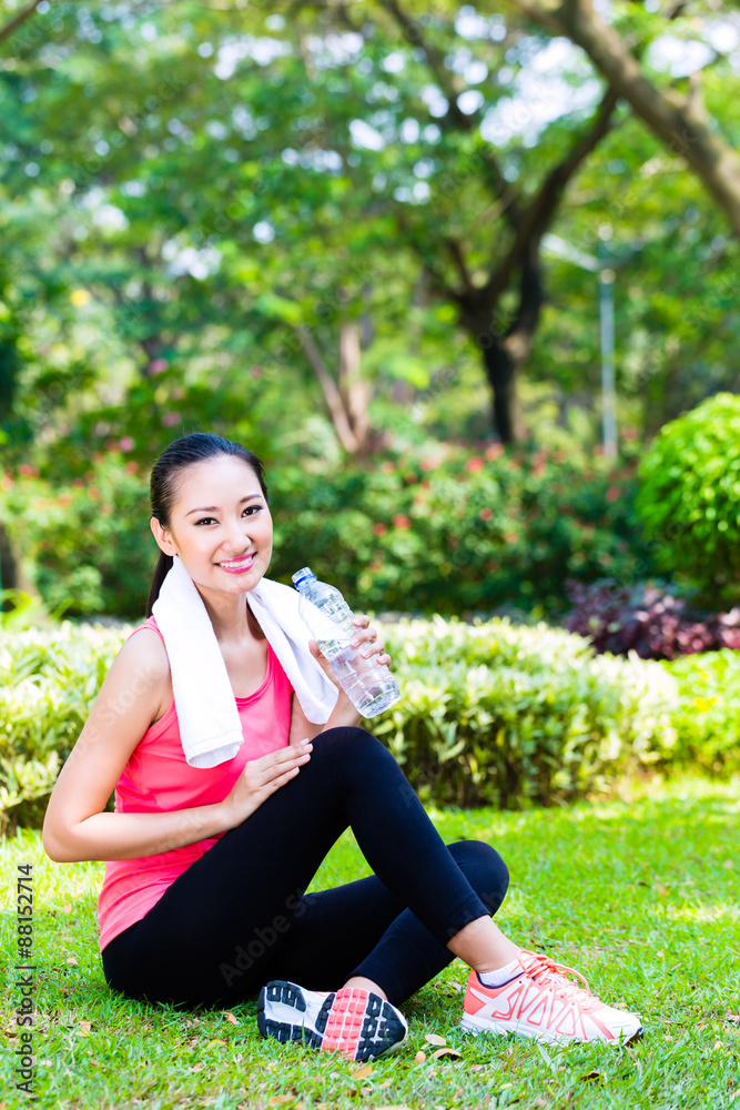 Asian Chinese woman drinking water after sport in park Asian Chinese woman drinking water after sport in park