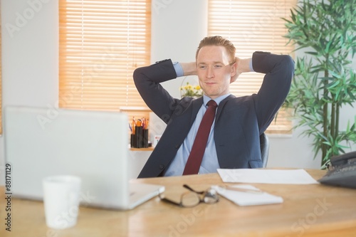 Relaxed businessman sitting back at desk