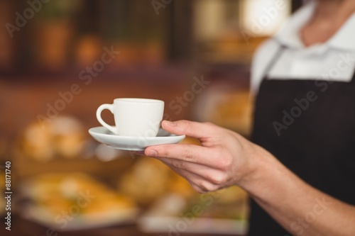 Barista offering cup of coffee